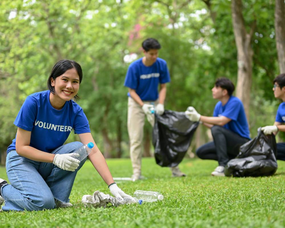 Team of volunteers cleaning up litter from a park to make a positive impact on their business